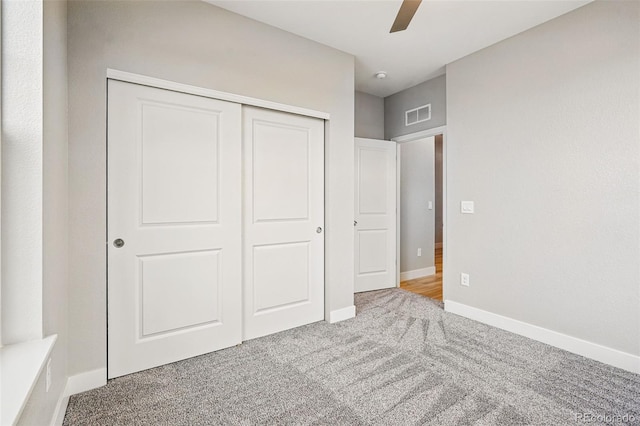 unfurnished bedroom featuring carpet floors, baseboards, visible vents, and a closet
