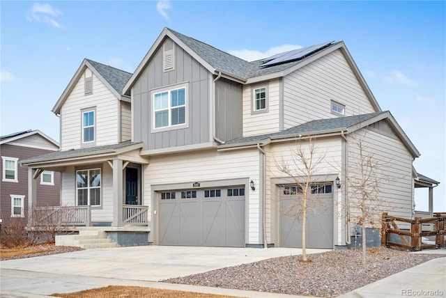 view of front of house with solar panels, a porch, and a garage