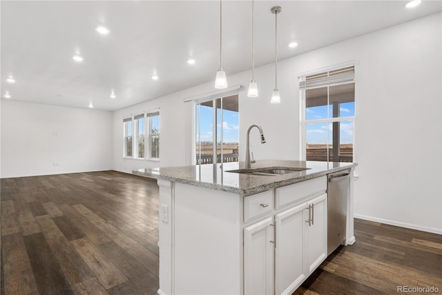 kitchen with sink, white cabinetry, light stone counters, stainless steel dishwasher, and a kitchen island with sink