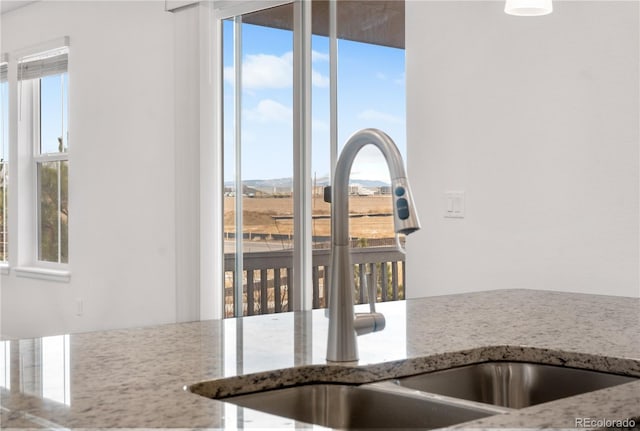 kitchen featuring sink and light stone countertops