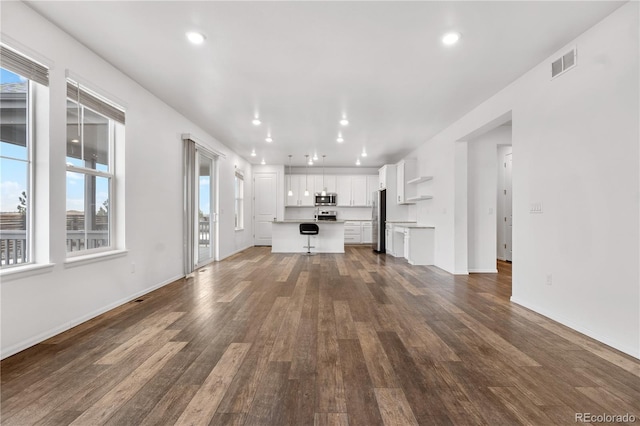 unfurnished living room with plenty of natural light and wood-type flooring