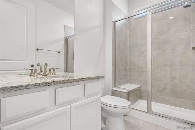 bathroom featuring tile patterned floors, an enclosed shower, vanity, and toilet