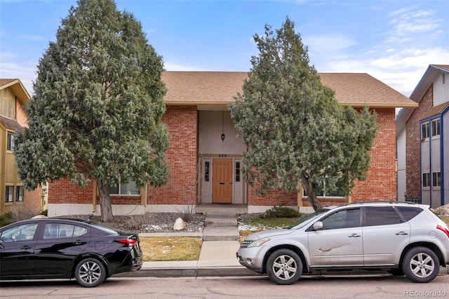 995 Holli Springs Ln, Colorado Springs, CO 80907 - obstructed view of property featuring brick siding and a shingled roof