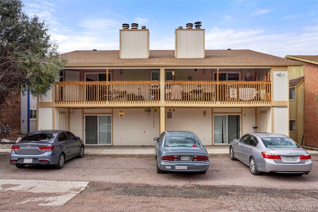 995 Holli Springs Ln, Colorado Springs, CO 80907 - back of property featuring a chimney, a balcony, and a shingled roof