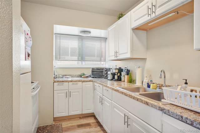 995 Holli Springs Ln, Colorado Springs, CO 80907 - kitchen featuring white cabinets, light wood-style floors, light countertops, and a sink