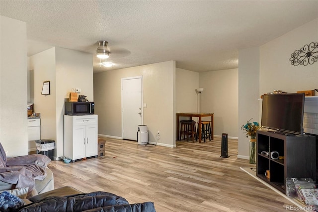 995 Holli Springs Ln, Colorado Springs, CO 80907 - living area featuring light wood-style floors, a textured ceiling, baseboards, and a ceiling fan