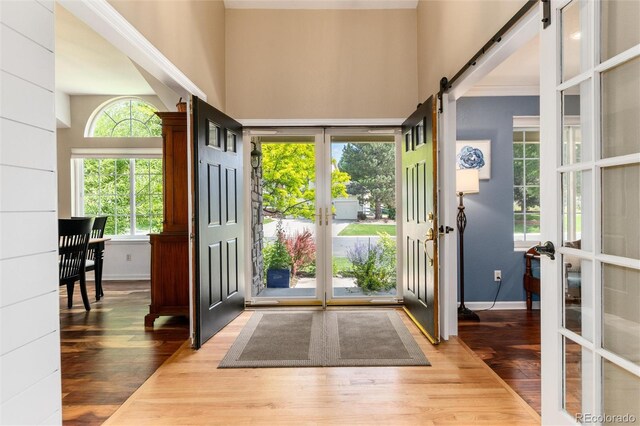 2480 W Jamison Way, Littleton, CO 80120 - foyer entrance featuring a barn door, wood finished floors, and a high ceiling