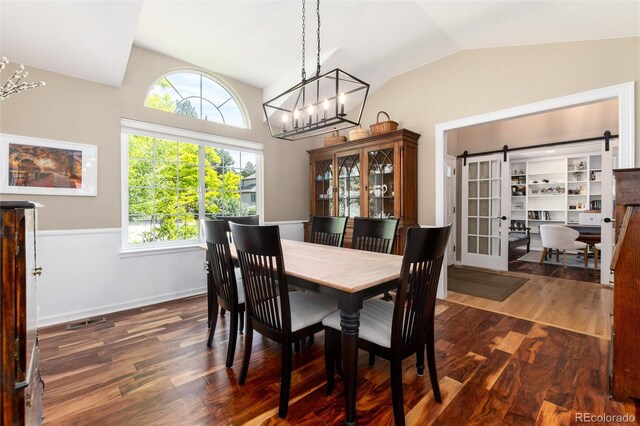 2480 W Jamison Way, Littleton, CO 80120 - dining space featuring lofted ceiling, dark wood finished floors, and a chandelier