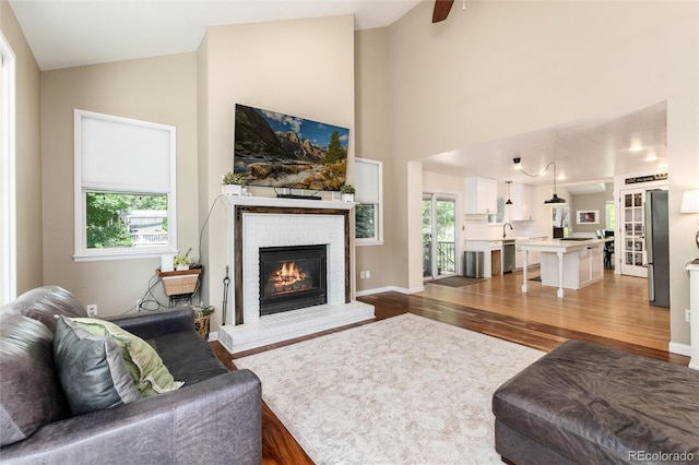 2480 W Jamison Way, Littleton, CO 80120 - living area with dark wood-style floors, a brick fireplace, and high vaulted ceiling
