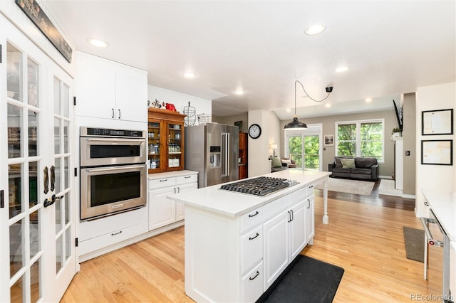 2480 W Jamison Way, Littleton, CO 80120 - kitchen featuring appliances with stainless steel finishes, a center island, french doors, light wood-style flooring, and recessed lighting