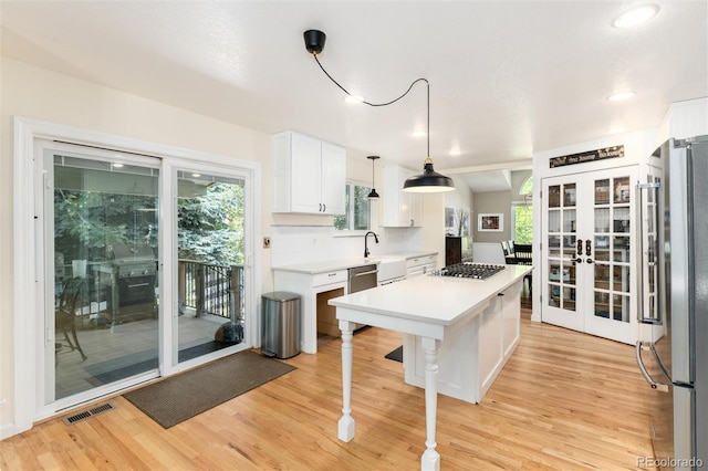 2480 W Jamison Way, Littleton, CO 80120 - kitchen with appliances with stainless steel finishes, french doors, light wood-type flooring, white cabinets, and recessed lighting