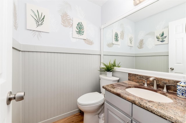 2480 W Jamison Way, Littleton, CO 80120 - half bath featuring vanity, a wainscoted wall, and wood finished floors