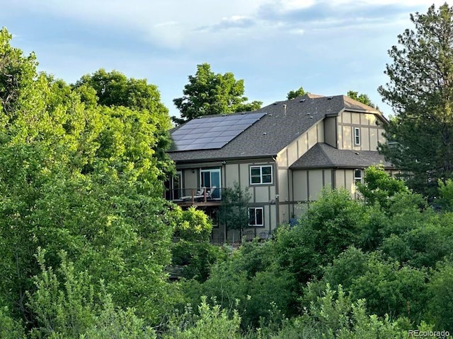 2480 W Jamison Way, Littleton, CO 80120 - rear view of property featuring roof mounted solar panels, a balcony, and roof with shingles