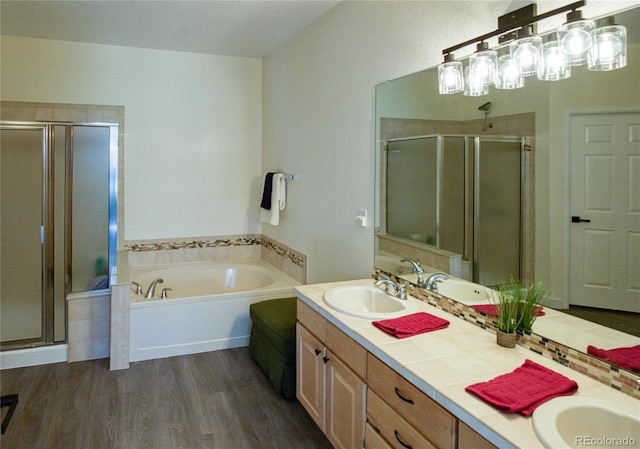 13708 Legend Trl Unit 101, Broomfield, CO 80023 - full bath with double vanity, wood finished floors, a sink, a garden tub, and a stall shower