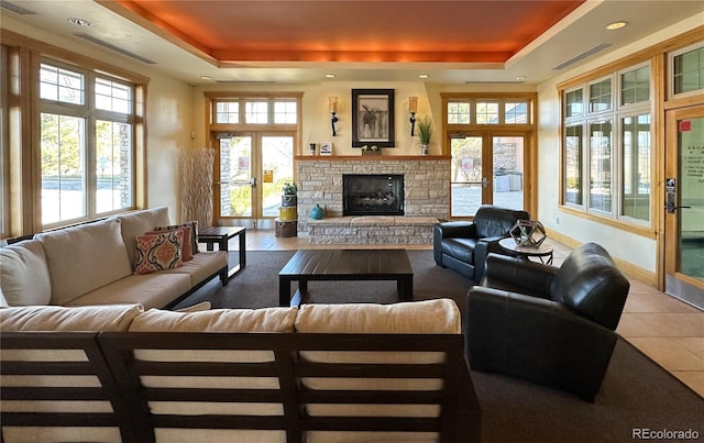 13708 Legend Trl Unit 101, Broomfield, CO 80023 - living room with a raised ceiling, a stone fireplace, a healthy amount of sunlight, and tile patterned floors