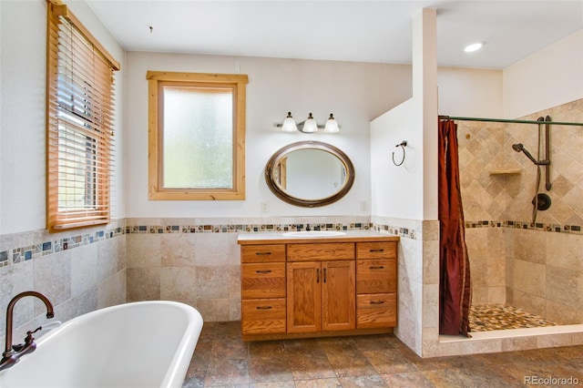 bathroom featuring tile walls, plus walk in shower, and a healthy amount of sunlight