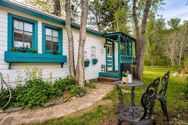 view of exterior entry featuring a lawn