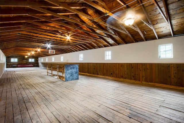 bonus room with lofted ceiling with beams, hardwood / wood-style flooring, wooden walls, and wood ceiling