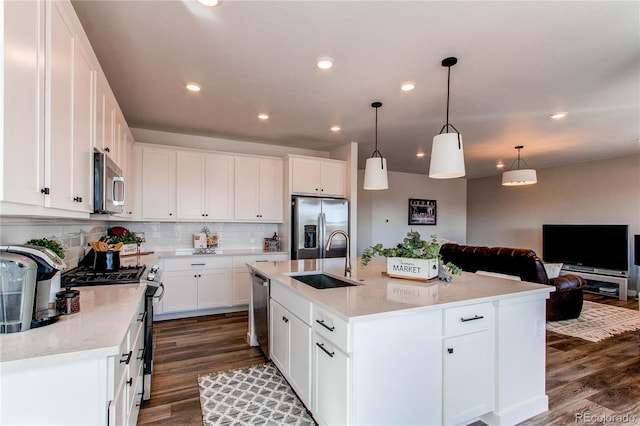 kitchen with dark wood-type flooring, a sink, tasteful backsplash, stainless steel appliances, and white cabinets