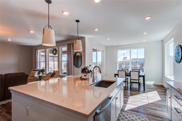 kitchen with light stone counters, dark wood-style floors, recessed lighting, and a sink