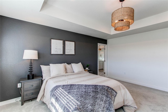 bedroom featuring light colored carpet, a raised ceiling, and baseboards