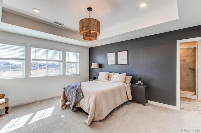 bedroom featuring visible vents, a raised ceiling, baseboards, and light carpet