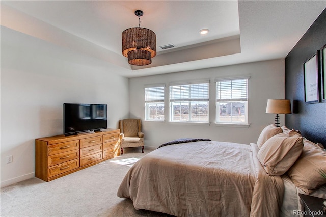 carpeted bedroom featuring visible vents, a raised ceiling, and baseboards