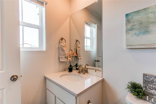 bathroom with vanity and a textured wall