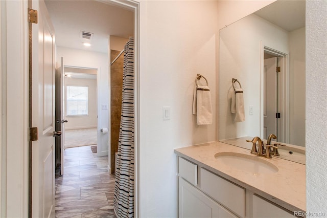 bathroom featuring baseboards, visible vents, vanity, and a shower with curtain