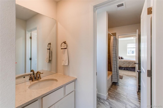 bathroom with visible vents, a washtub, vanity, and a shower