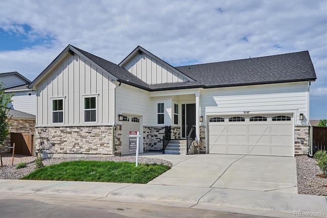 9197 Ironwood St, Highlands Ranch, CO 80129 - view of front of property with board and batten siding, an attached garage, stone siding, and driveway