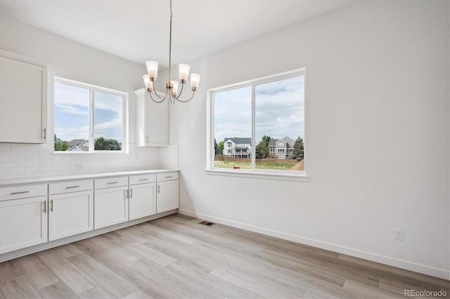 9197 Ironwood St, Highlands Ranch, CO 80129 - unfurnished dining area featuring light wood-style floors, a chandelier, and healthy amount of natural light