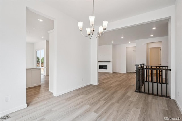 9197 Ironwood St, Highlands Ranch, CO 80129 - empty room featuring light wood-style flooring, a chandelier, and recessed lighting