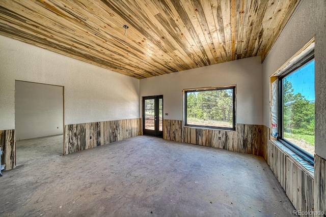 1341 County Road 327, Westcliffe, CO 81252 - unfurnished room featuring a wainscoted wall, unfinished concrete flooring, wooden ceiling, wood walls, and a textured wall