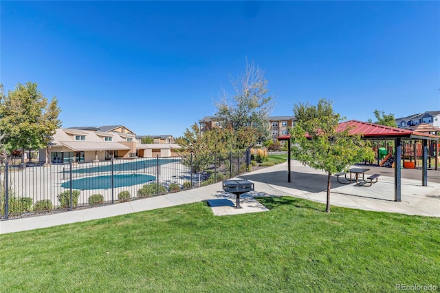 view of pool with a playground, a patio area, and a lawn