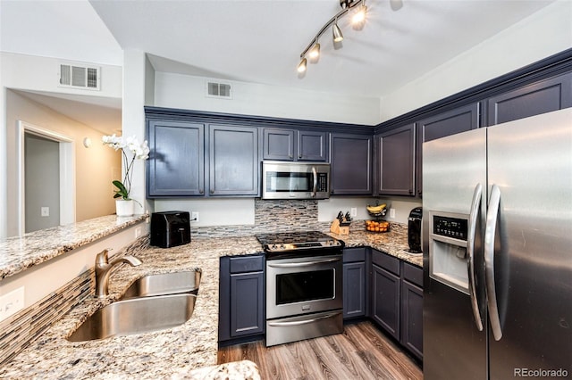 8500 E Jefferson Ave Unit 19B, Denver, CO 80237 - kitchen featuring stainless steel appliances, wood finished floors, light stone counters, backsplash, and track lighting
