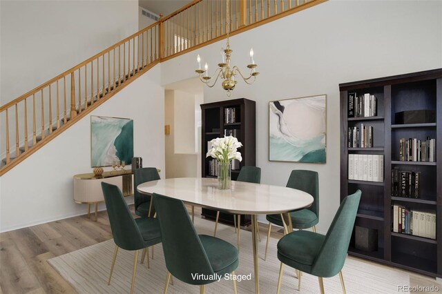 21968 E Princeton Dr, Aurora, CO 80018 - dining space with wood finished floors, a chandelier, stairway, and a high ceiling