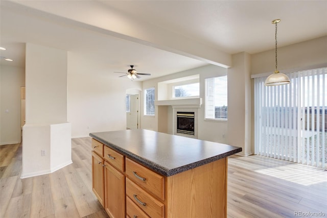 21968 E Princeton Dr, Aurora, CO 80018 - kitchen with dark countertops, light wood-type flooring, healthy amount of natural light, and a glass covered fireplace