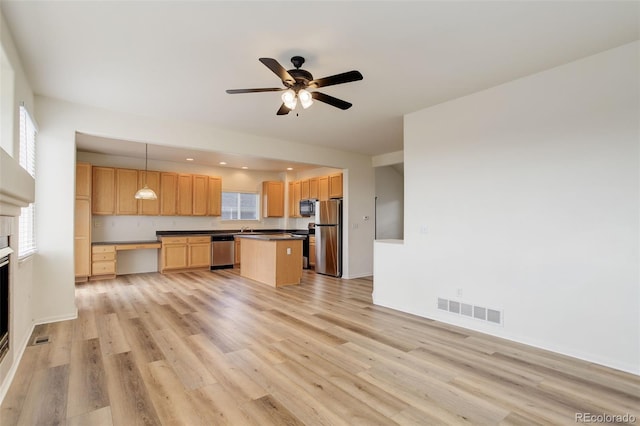 21968 E Princeton Dr, Aurora, CO 80018 - kitchen featuring stainless steel appliances, dark countertops, light wood-type flooring, a kitchen island, and recessed lighting