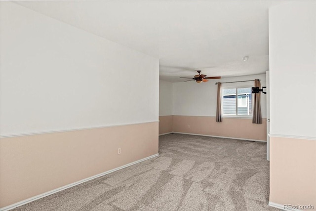 spare room with a ceiling fan, carpet flooring, and baseboards