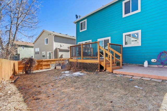 rear view of house featuring a fenced backyard and a deck