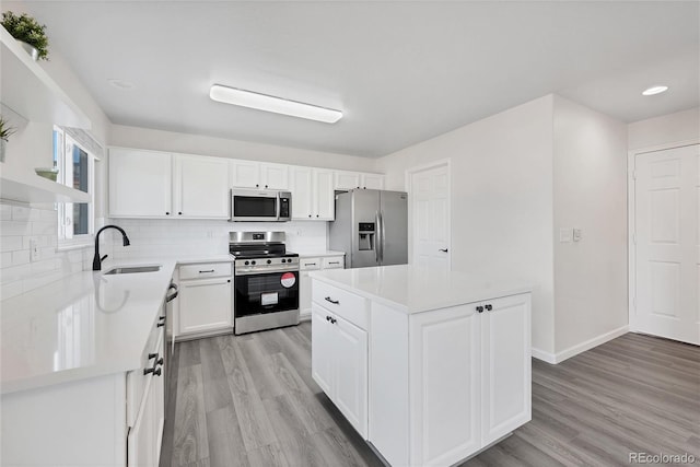 kitchen featuring a sink, decorative backsplash, appliances with stainless steel finishes, and light countertops