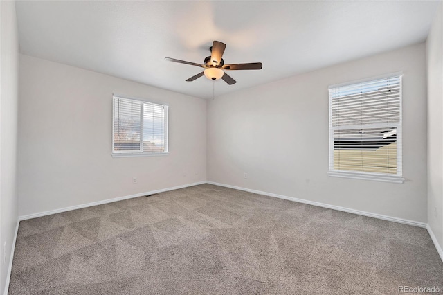 unfurnished room with carpet floors, baseboards, and a ceiling fan