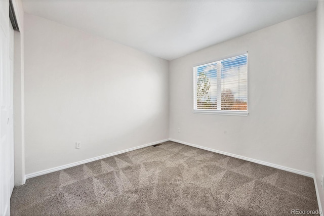 empty room with baseboards and carpet