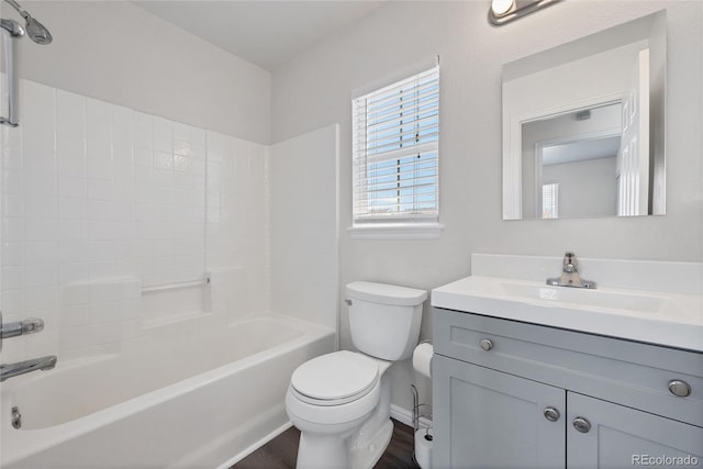 bathroom with vanity, wood finished floors, toilet, baseboards, and shower / tub combination