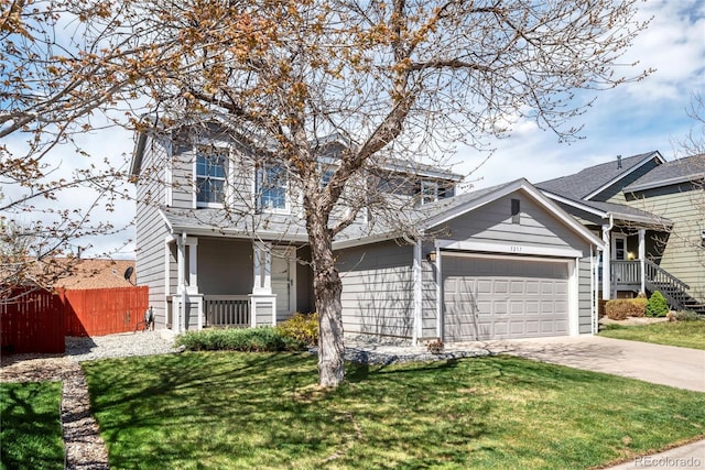traditional-style house featuring fence, a front lawn, driveway, and a garage