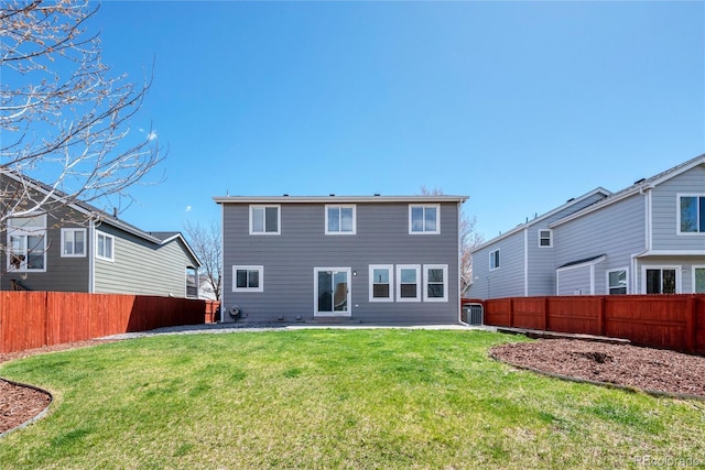 rear view of house featuring a lawn, a fenced backyard, and a patio area