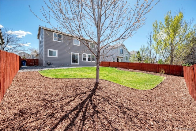 back of property with a fenced backyard and a yard