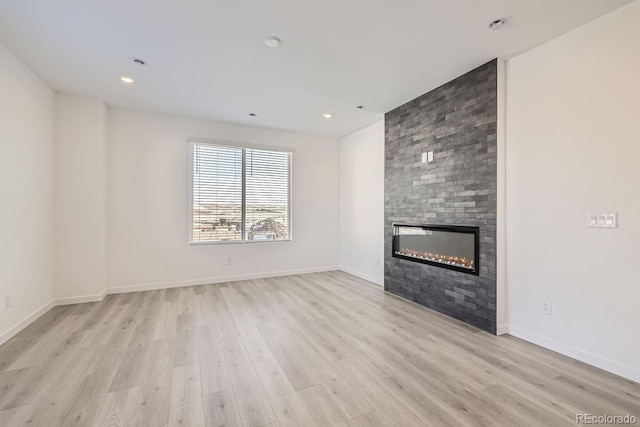 unfurnished living room featuring a fireplace and light hardwood / wood-style flooring