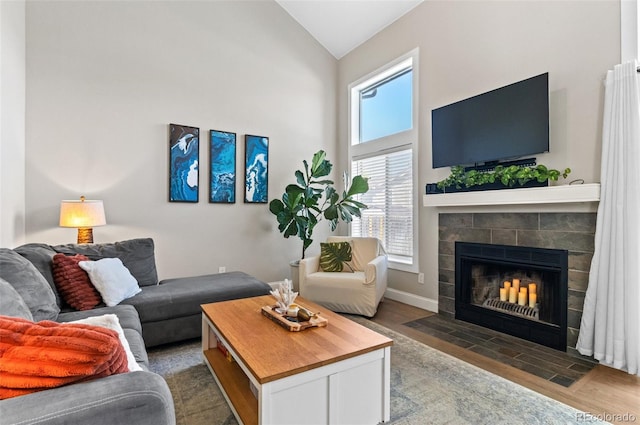 living room with a fireplace, dark hardwood / wood-style flooring, and high vaulted ceiling